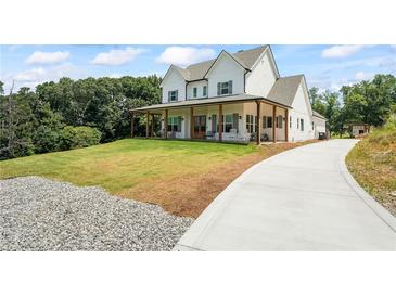 Stunning two-story modern farmhouse with a welcoming porch and well-manicured lawn at 5315 Hendrix Rd, Cumming, GA 30040