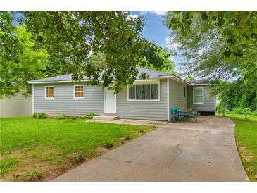 Charming single-story home with a well-maintained lawn, siding, and a cozy seating area on the driveway at 2199 Clairmont Cir, Snellville, GA 30078