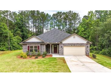 Charming single-story home featuring brick accents, a well-manicured lawn, and attached two car garage at 509 Grace Ln, Villa Rica, GA 30180
