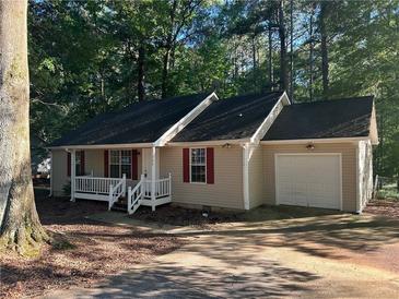 Charming single-story home featuring a front porch, red shutters, and an attached garage, nestled among mature trees at 796 Cohran Store Rd, Douglasville, GA 30134