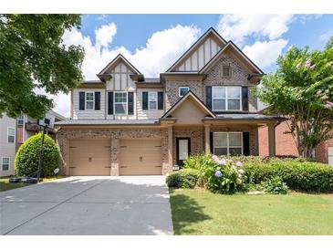 Charming two-story brick home featuring a two-car garage, landscaped yard, and covered front porch at 812 Autry Oak Ct, Alpharetta, GA 30022