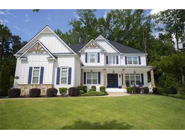 Charming two-story home with white siding, navy shutters, covered porch, and lush green lawn at 1895 Henley Way, Alpharetta, GA 30009
