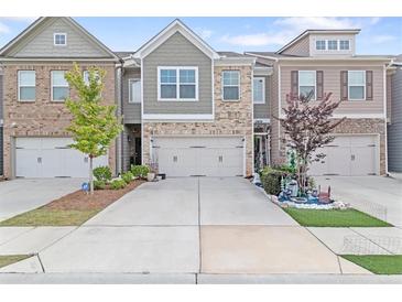 Charming townhome featuring brick facade, inviting curb appeal, and attached one-car garage at 2404 Fitts Dr, Conyers, GA 30094
