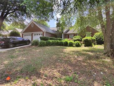 Charming brick home featuring an attached two-car garage and mature landscaping at 3587 Plum Creek Nw Trl, Kennesaw, GA 30152