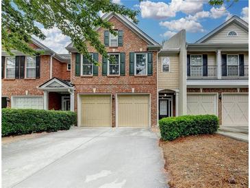 Charming brick townhome with a two-car garage and well-maintained landscaping at 2515 Gadsen Walk, Duluth, GA 30097