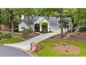 Charming home with a circular driveway and a well-manicured front lawn surrounded by mature trees at 625 Wynfield Ct, Roswell, GA 30076