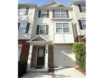 Charming townhouse featuring a brick facade, attached garage, and a welcoming entrance at 6817 Blackstone Pl # 16, Mableton, GA 30126