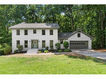 Charming two-story home with a manicured lawn and a two car garage surrounded by mature trees at 5236 Forest Brook Pkwy, Marietta, GA 30068