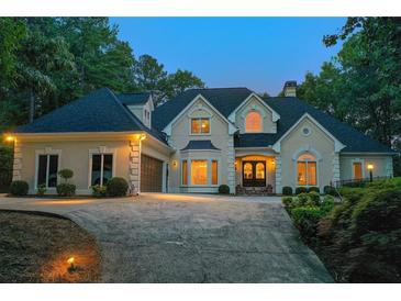 Stately home with manicured landscaping, circular driveway, and exterior lighting creates a welcoming ambiance at 2885 Coles Way, Atlanta, GA 30350