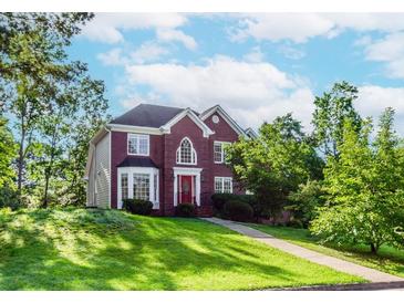 Charming brick two-story home with a red front door, lush lawn, and mature trees at 1100 Midland Way, Lawrenceville, GA 30043