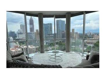 Modern living room featuring floor-to-ceiling windows showcasing city skyline views at 285 Centennial Olympic Park Nw Dr # 1905, Atlanta, GA 30339