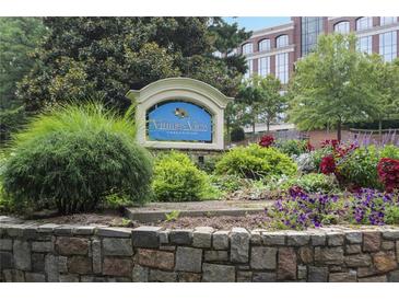 Landscaped entrance sign for Vinings View Condominiums with stone base, lush greenery and colorful flowers at 3160 Seven Pines Unit 105 Ct, Atlanta, GA 30339