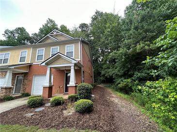 Charming townhome featuring a brick facade, well-kept landscaping, and an attached single car garage at 1788 Arbor Gate Dr # 1505, Lawrenceville, GA 30044