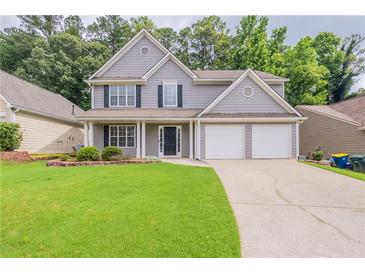 Charming gray two-story home with a well-manicured lawn and a two-car garage at 4271 Brighton Nw Way, Kennesaw, GA 30144
