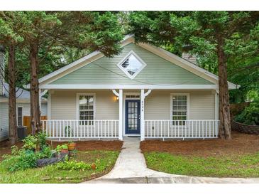 Charming bungalow features a quaint front porch, fresh paint, and mature trees at 4594 Poplar Rd, Pine Lake, GA 30072