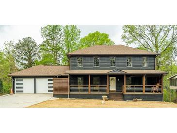 Charming two-story home featuring a front porch, two-car garage, neutral paint, and mature trees at 5254 Greenpoint Drive, Stone Mountain, GA 30088