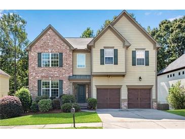 Charming two-story home featuring a brick facade, green shutters, and a well-manicured lawn at 5688 Baffin Rd, Atlanta, GA 30349