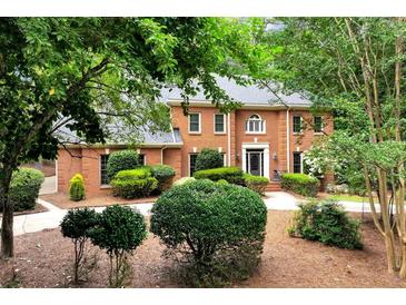 Beautiful two-story brick home featuring a well-manicured lawn and lush, mature landscaping for added privacy at 1320 Northcliff Trce, Roswell, GA 30076