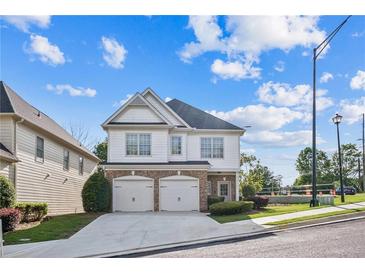 Charming two-story home featuring a brick and siding facade, a two-car garage, and a well-maintained front yard at 296 Water Oak Pl, Alpharetta, GA 30009