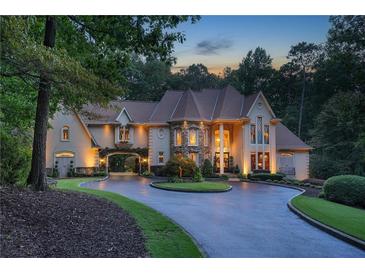 Elegant estate with circular drive, porte-cochere, lush landscaping, and stone accents at 1500 Historic Vw, Stone Mountain, GA 30087