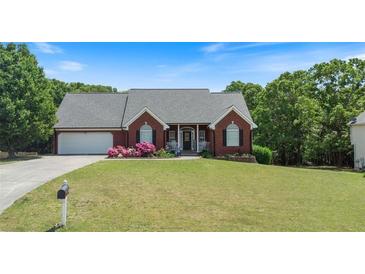 Charming brick home features a well-manicured lawn and colorful flower beds at 20 Friendship Rd, Euharlee, GA 30145