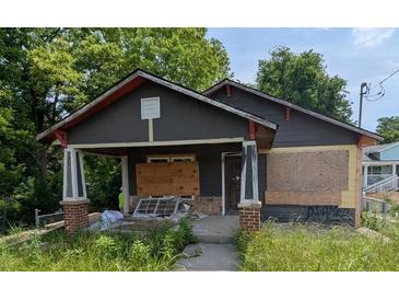 Exterior of home showing gray siding, stone porch, and overgrown front yard at 854 Mcdonough Se Blvd, Atlanta, GA 30315