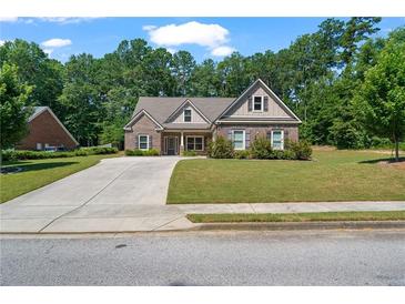 Charming single-Gathering home with brick facade, manicured lawn, and a paved driveway leading to a cozy entrance at 902 Edgewater Dr, Loganville, GA 30052