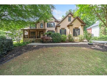 Charming two-story home featuring a well-manicured lawn and beautiful landscaping with mature trees at 3438 Winborn Walk Northwest Nw, Kennesaw, GA 30152