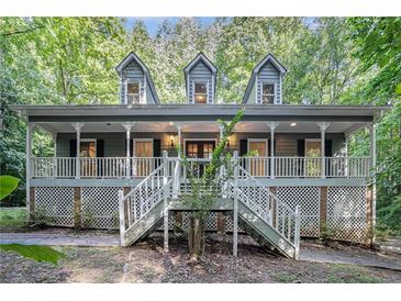 Charming home with a large front porch, detailed railings and three dormer windows above at 1488 White Columns Blvd, Canton, GA 30115