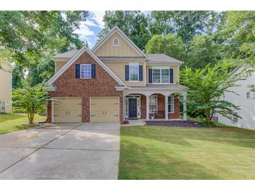 Charming two-story home features a brick and tan exterior, a well-manicured lawn, and a two-car garage at 4092 Duran Ln, Auburn, GA 30011