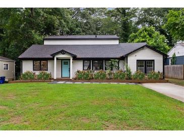 Charming single-story home with manicured lawn, flowerbeds, and a bright blue front door at 1218 Crestwood Se Dr, Atlanta, GA 30316