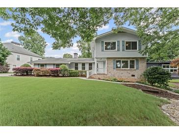 Charming two-story home featuring a lush lawn and beautiful landscaping at 2737 Fontainebleau Drive, Dunwoody, GA 30360