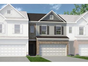 Charming two-story townhome with a two-car garage and a mix of brick and gray siding at 22 Jacobs Farm Ln # 11, Lawrenceville, GA 30045