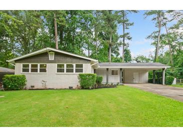 Charming single-story home featuring a brick facade, well-manicured lawn, and a covered carport, nestled in a lush, green landscape at 3222 Edgemont Way, Decatur, GA 30032