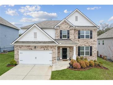 Charming two-story home with a well-manicured lawn, brick facade, and an attached two-car garage at 4365 Sunflower Cir, Cumming, GA 30040