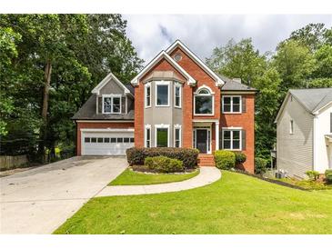 Charming two-story brick home with a well-manicured front lawn and attached two-car garage at 1612 Branch Creek Cv, Lawrenceville, GA 30043