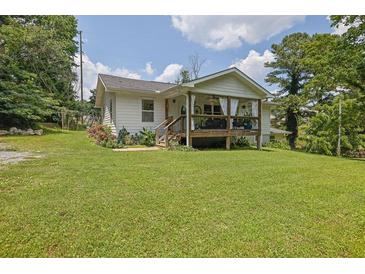 Charming home with a welcoming front porch and lush green lawn, perfect for outdoor living at 3411 Morgan Rd, Canton, GA 30115