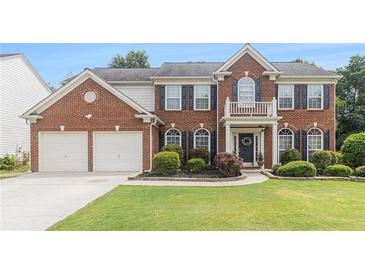 Beautiful two-story brick home with manicured lawn, shutters and white trim accents at 122 Susobell Pl, Woodstock, GA 30188