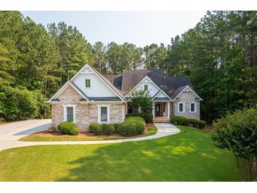 Charming brick home features a well-manicured lawn and mature trees at 390 Glengarry Chase, Covington, GA 30014