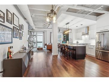 Bright open-concept living room and kitchen featuring hardwood floors and modern decor at 805 Peachtree Ne St # 411, Atlanta, GA 30308