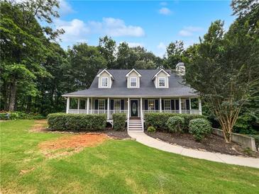 Charming home featuring a cozy front porch and well-manicured landscaping at 643 Windy Mill Way, Temple, GA 30179