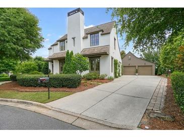 Charming home with a manicured front yard, long driveway, and detached garage providing ample parking at 6930 Wesley Hughes Rd, Cumming, GA 30040