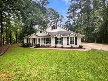 Charming one-story home with white siding, black shutters, and a well-maintained green lawn at 46 Timber Walk Dr, Sharpsburg, GA 30277