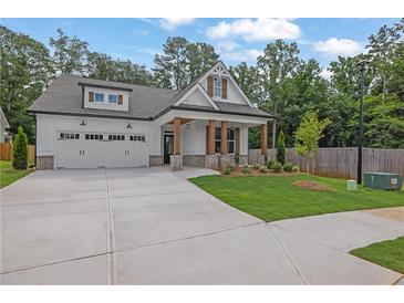 Charming two-story home featuring a manicured lawn, craftsman architecture, and a two-car garage at 153 Alaina Rd, Holly Springs, GA 30115