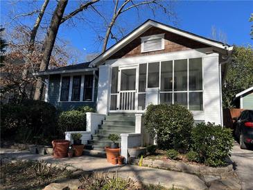 Charming home featuring a screened porch and landscaped front yard with mature trees at 284 Lakeview Ne Ave, Atlanta, GA 30305
