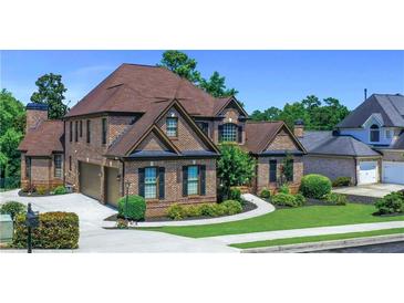 Beautiful two-story brick home featuring a manicured lawn, mature trees, and attached two-car garage at 3905 Greenside Ct, Dacula, GA 30019