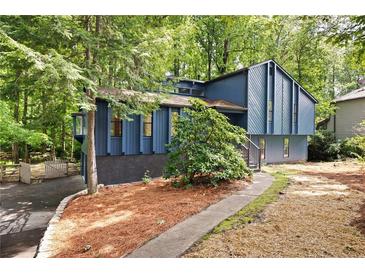 Charming blue two-story home with landscaped yard and inviting entryway, nestled among mature trees at 3292 Holly Mill Ct, Marietta, GA 30062