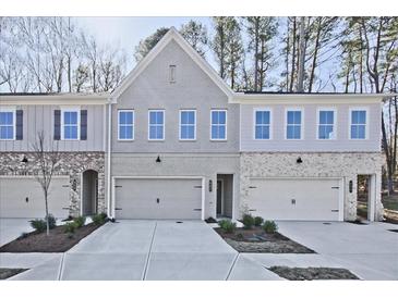 Charming townhome showcasing a mix of brick and siding with a spacious two-car garage and inviting curb appeal at 687 Sunstone Ln, Lawrenceville, GA 30043