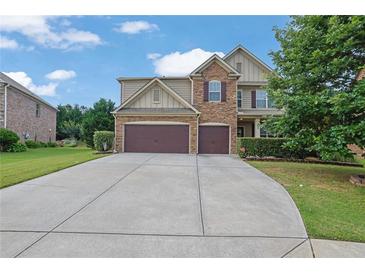 Charming two-story home with stone accents, a well-manicured lawn, and a spacious two car garage at 425 Eldridge Drive Dr, Suwanee, GA 30024