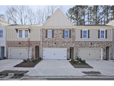 New brick and siding townhomes with attached garages and well-manicured landscaping at 691 Sunstone Ln, Lawrenceville, GA 30043